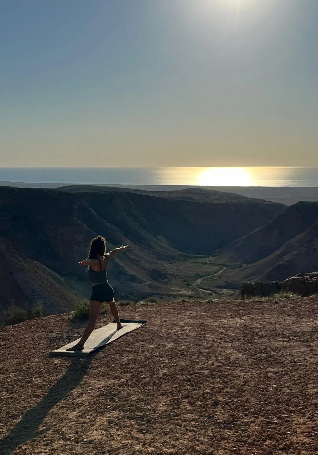 Cara in een yogahouding in een canyon in Australië